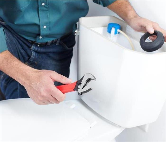 Person working on a toilet.