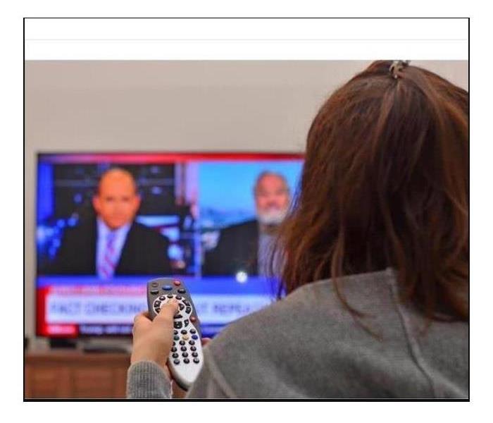 Woman watching tv and use remote controller 